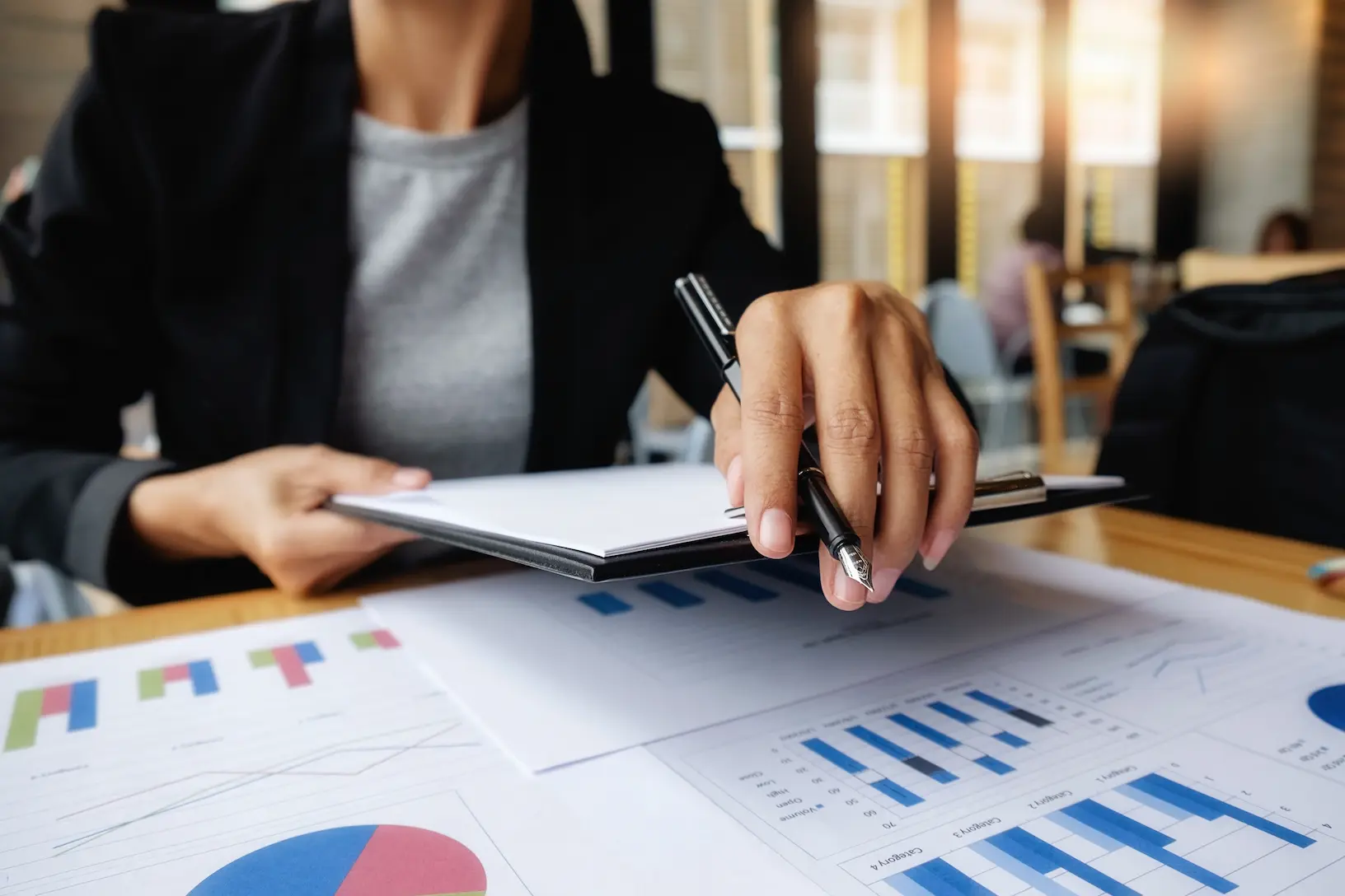 Manos de profesionales trabajando con documentos en una mesa